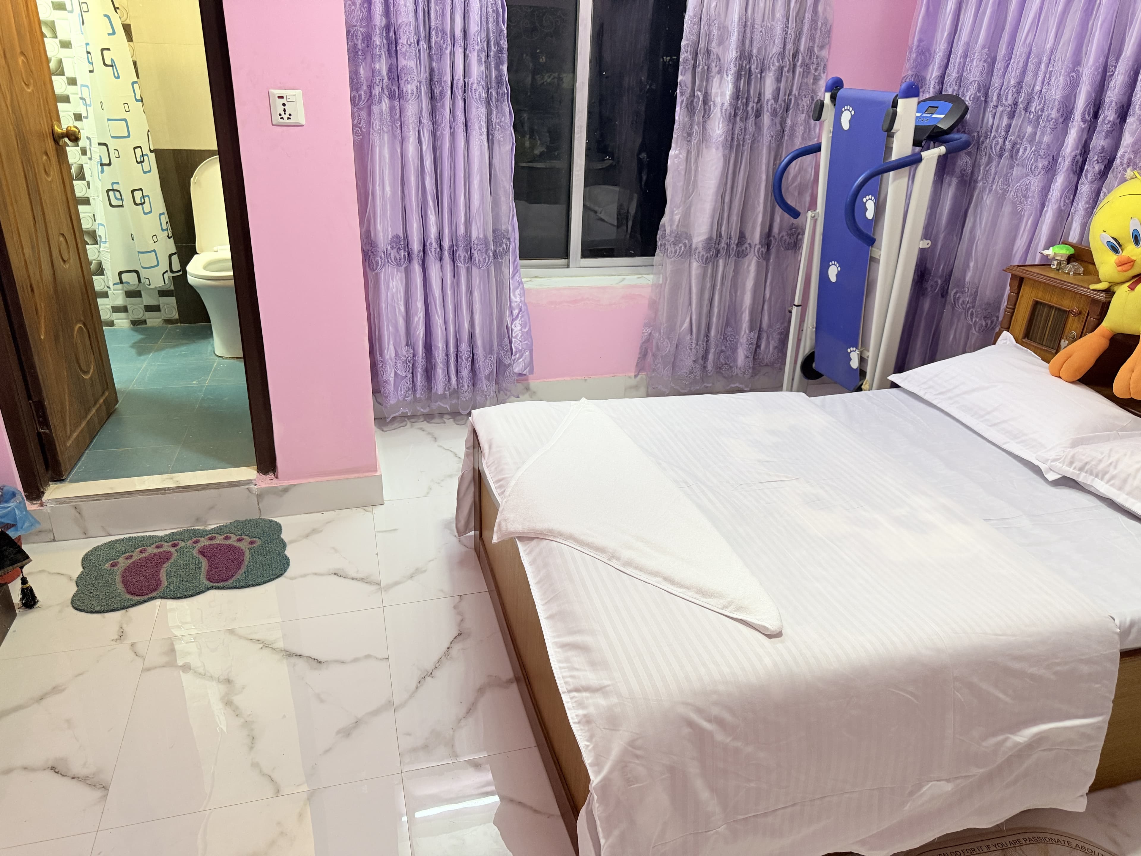 Guest bedroom with natural hill sunlight, attached bath, and in-room stepper