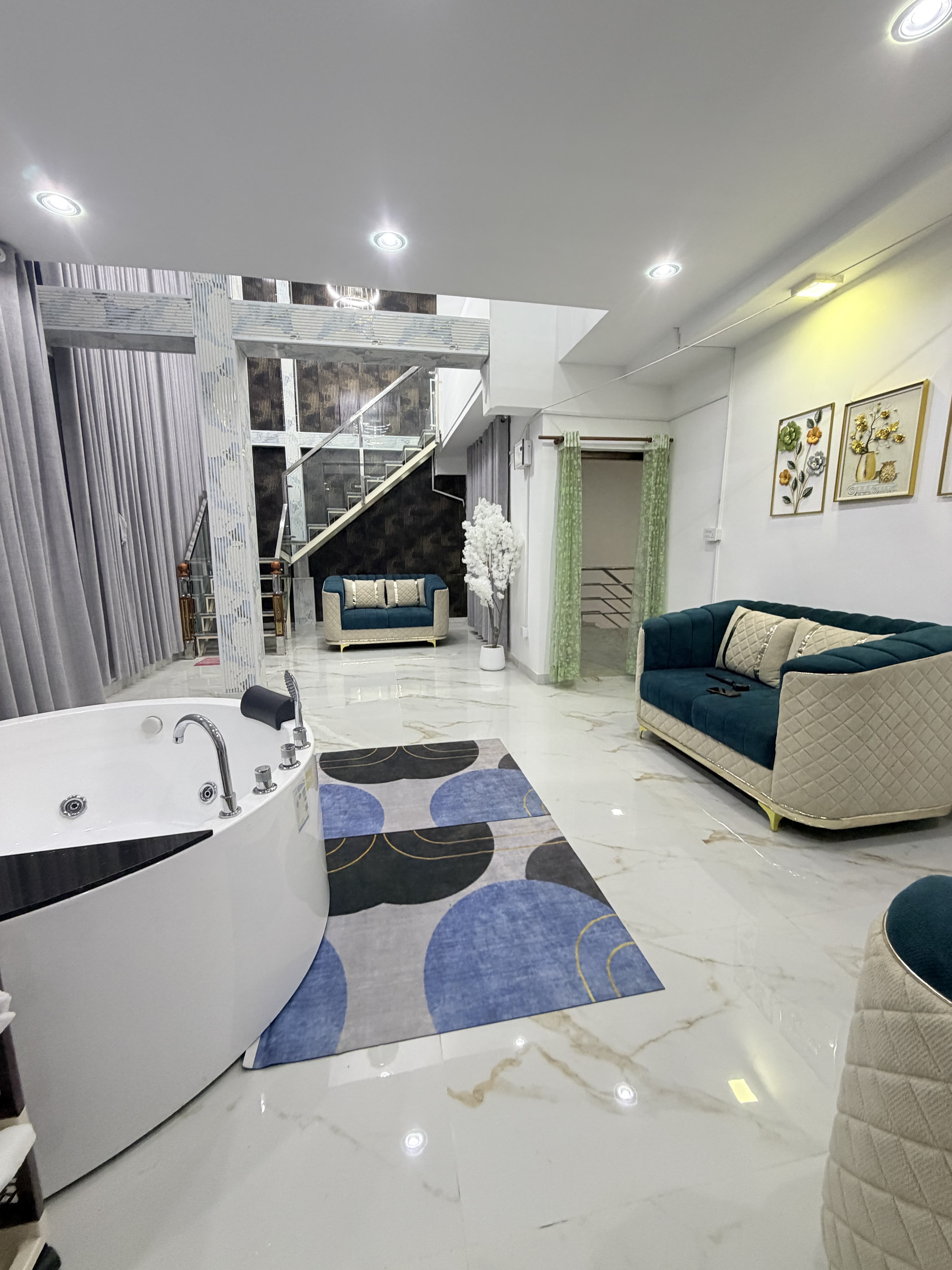 Private hydrotherapy Jacuzzi tub with emerald curved sofa and geometric rug
